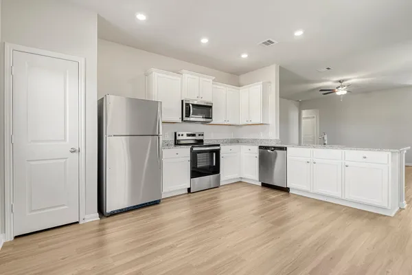 a kitchen with white cabinets and stainless steel appliances