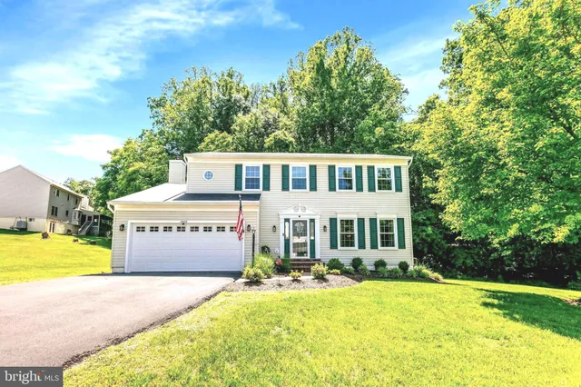 a front view of a house with yard and swimming pool