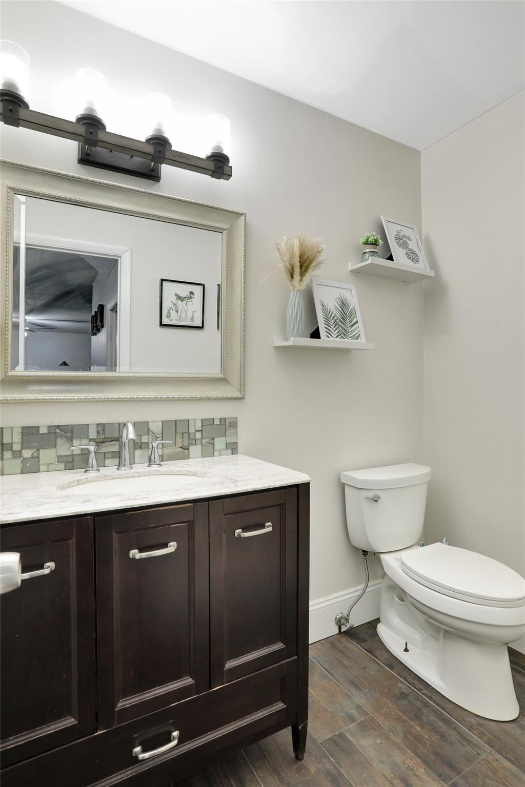9430 Southwest 61st Way, Unit A Boca Raton, FL 33428 - Photo 24 of 32 a bathroom with a toilet a sink and mirror
