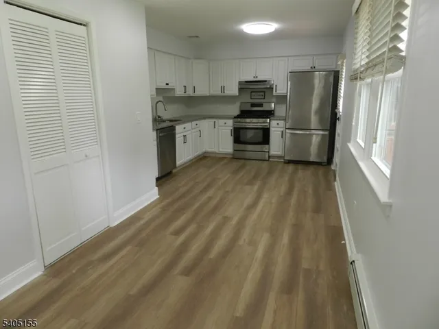 a kitchen with granite countertop a refrigerator and a sink