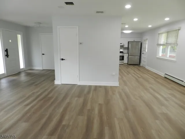 a view of empty room with wooden floor