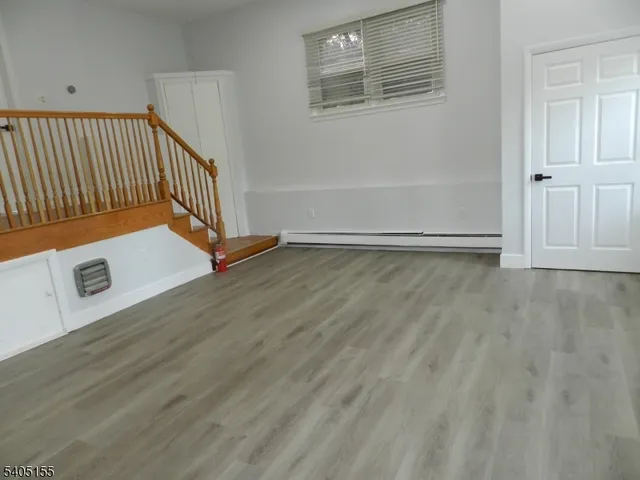 a view of an empty room with wooden floor