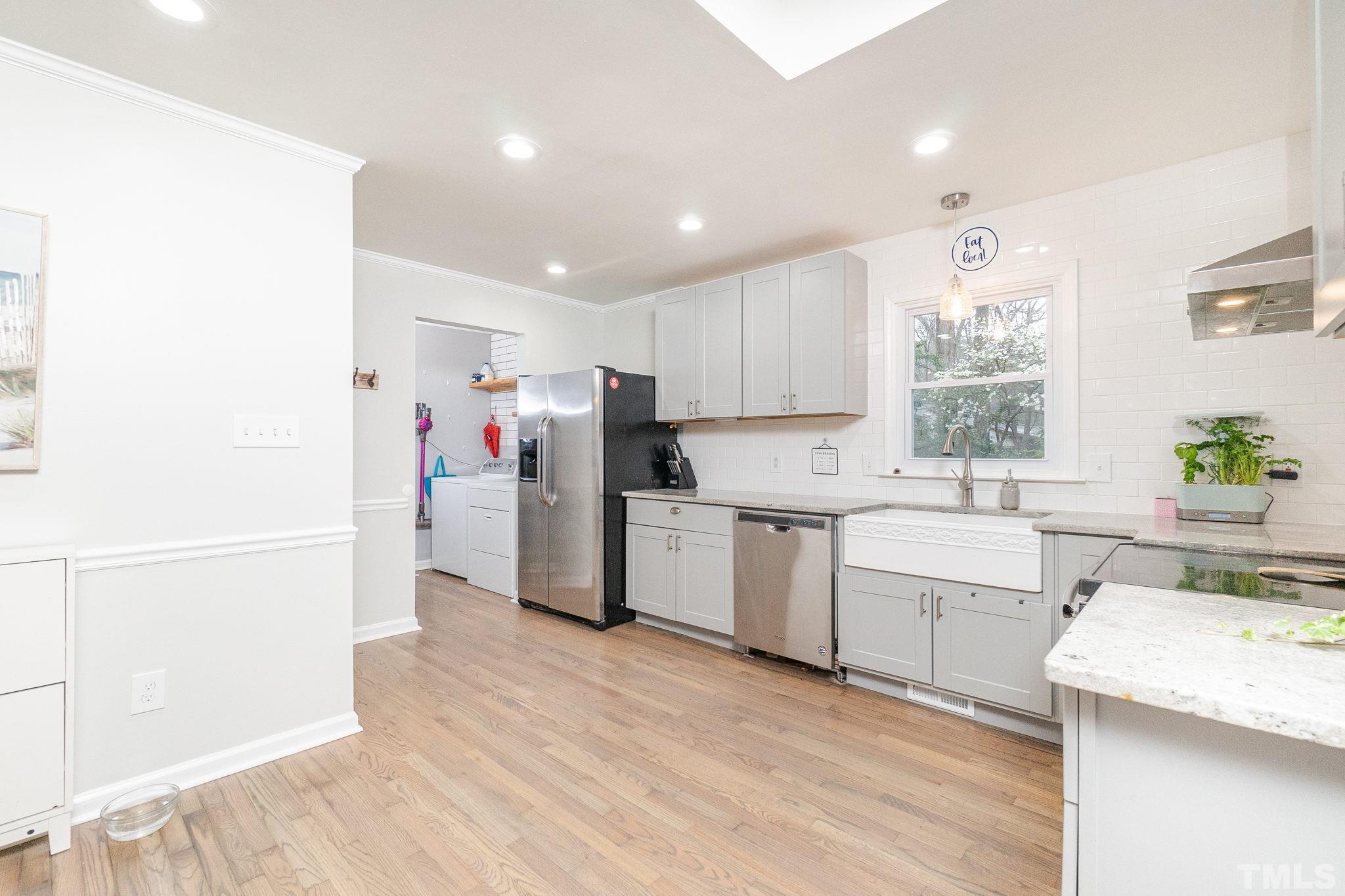 3316 Bearskin Court Raleigh, NC 27606 - Photo 8 of 27 a kitchen with a refrigerator a sink dishwasher with a dining table and chairs