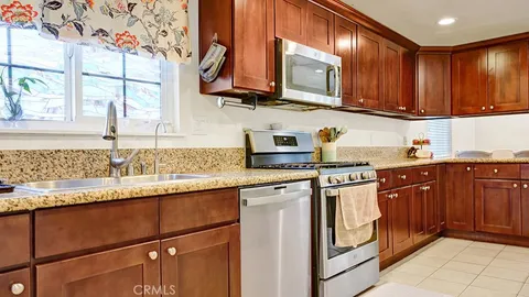 a kitchen with stainless steel appliances granite countertop wooden cabinets a sink and dishwasher