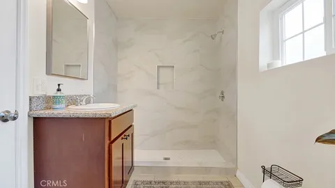 a bathroom with a shower sink and mirror