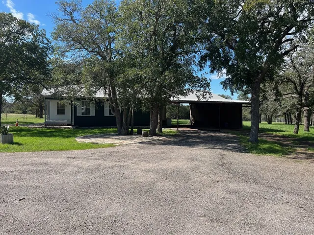 a view of a house with a yard and tree s