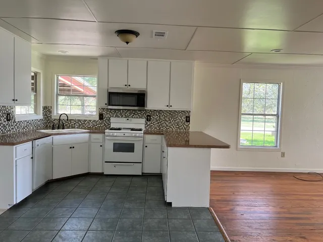 a kitchen with a stove sink and cabinets