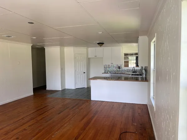 a view of kitchen cabinets and wooden floor