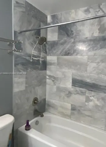 a bathroom with a white bath tub and a shower