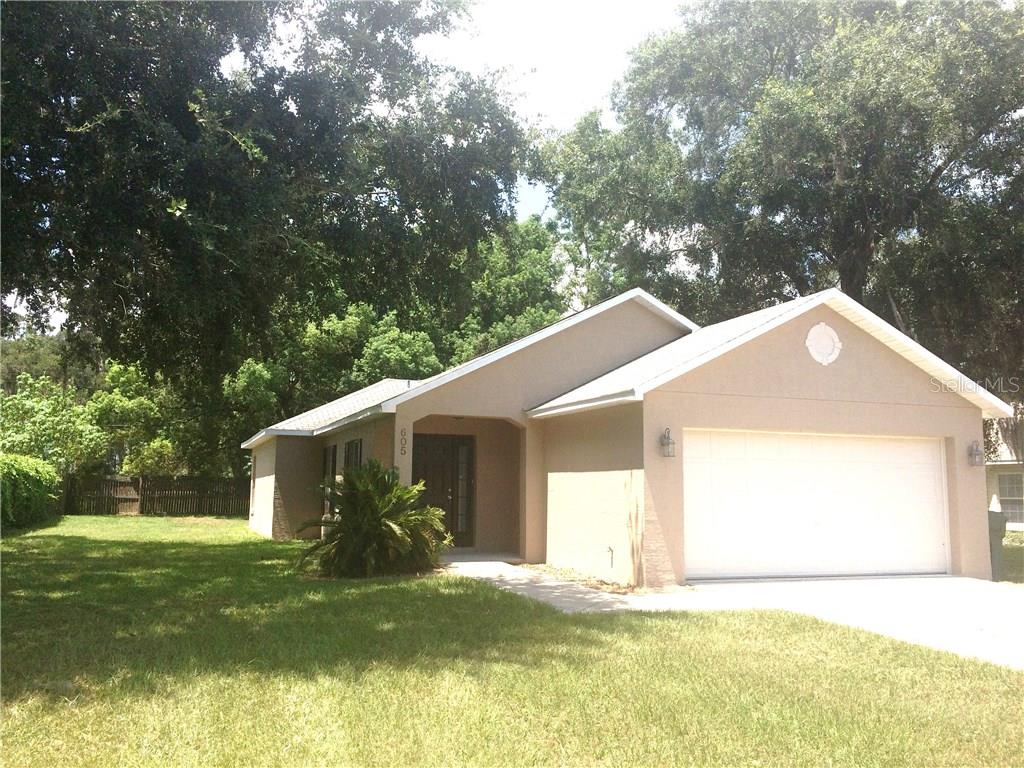 605 Flora View Lane Leesburg, FL 34748 - Photo 1 of 1 a view of a house with a yard garage and tree