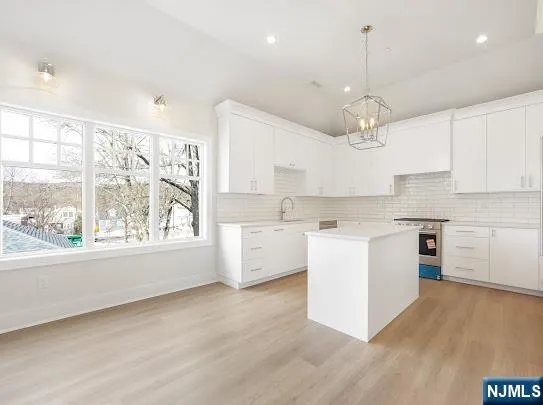 a large kitchen with kitchen island a large counter space a sink stainless steel appliances and cabinets