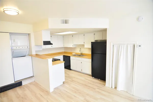 a kitchen with a stove a refrigerator and a sink