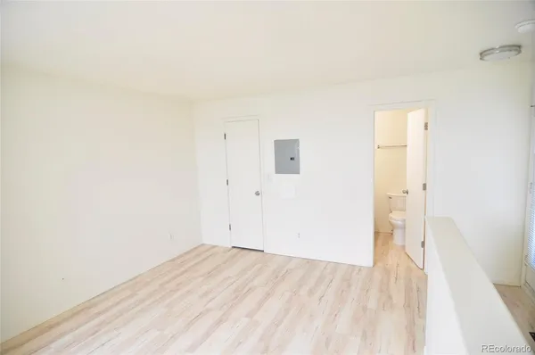 a view of a room with wooden floor and a bathroom