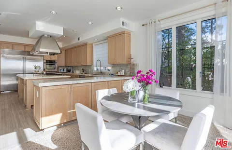a view of a dining room with furniture a kitchen and chandelier