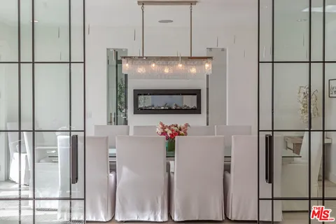 a dining room with furniture a chandelier and wooden floor