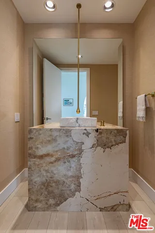a bathroom with a granite countertop sink and a mirror