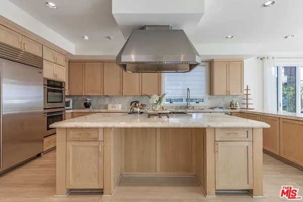 a kitchen with kitchen island granite countertop a sink stainless steel appliances and cabinets