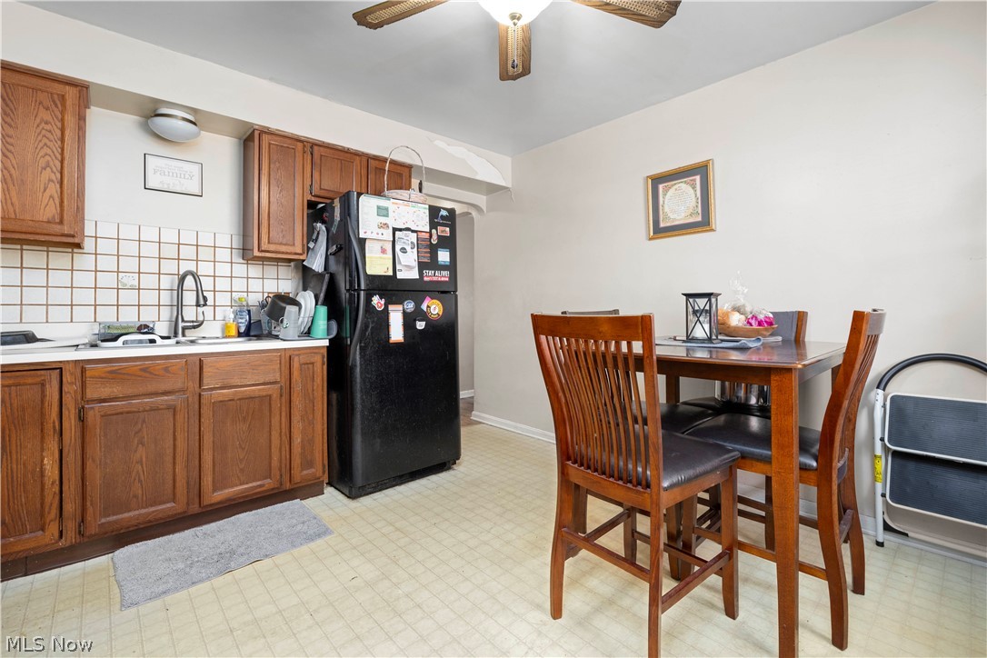 3305 Warren Road Cleveland, OH 44111 - Photo 17 of 28 Kitchen with backsplash, ceiling fan, black fridge, and light tile floors