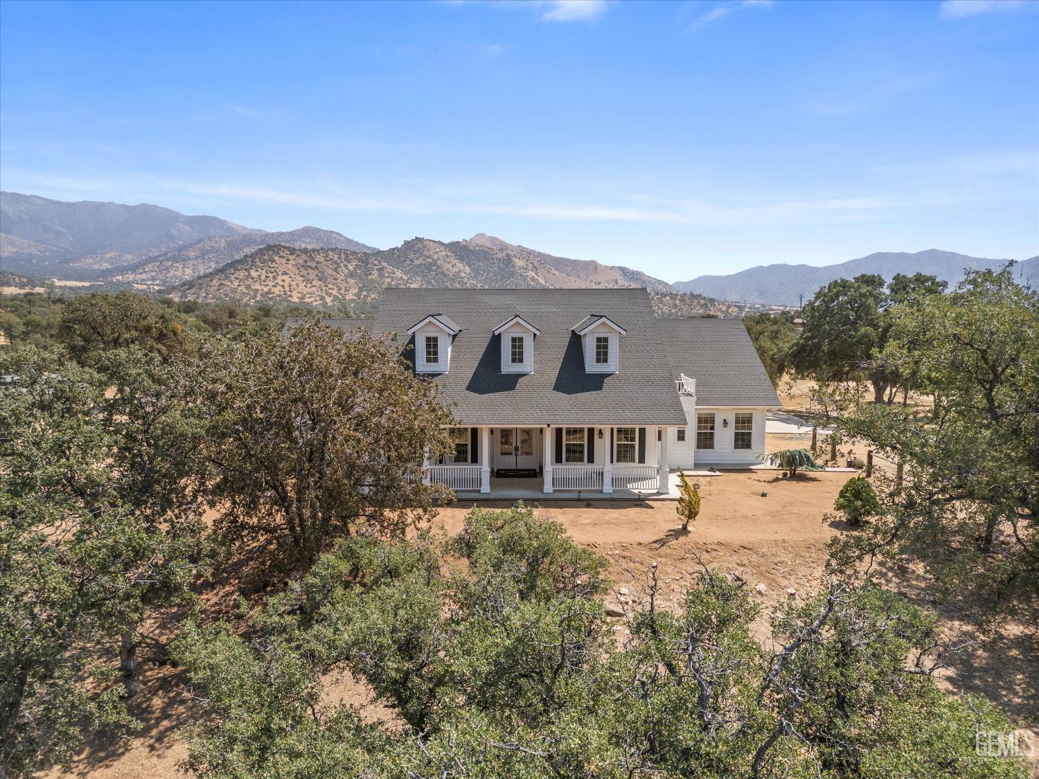 Undisclosed Address Caliente, CA 93518 - Photo 2 of 73 a view of a white house with a big yard and large tree