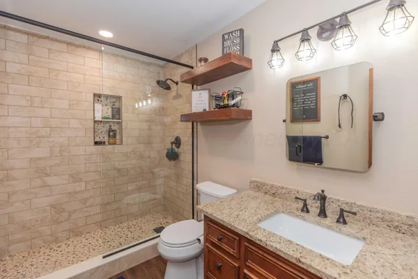 a bathroom with a granite countertop sink toilet and shower