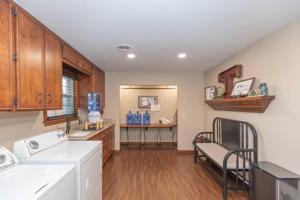 a kitchen with a sink cabinets and wooden floor
