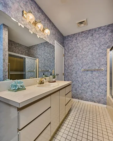 a bathroom with a sink a large mirror and a shower