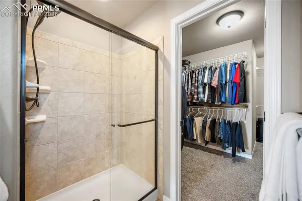 a view of walk in closet with clothes