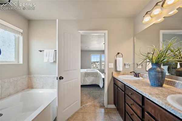 a bathroom with a tub sink and mirror