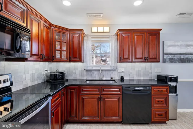 a kitchen with stainless steel appliances granite countertop a sink stove and microwave