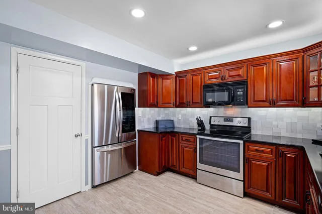 a kitchen with granite countertop stainless steel appliances and wooden cabinets