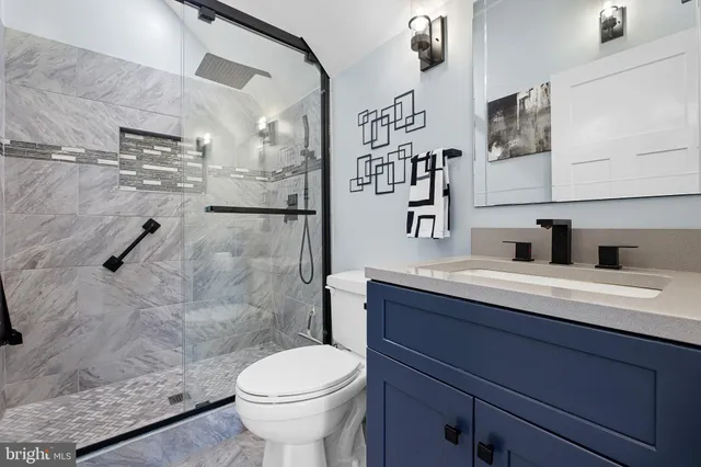 a bathroom with a sink a toilet and shower