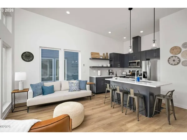a living room with stainless steel appliances kitchen island granite countertop furniture and a view of kitchen