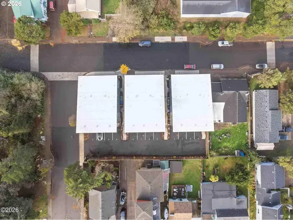 an aerial view of a house with a yard and large tree