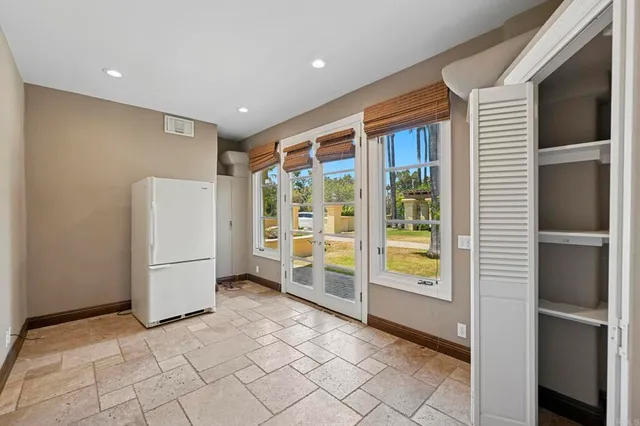 a view of an empty room with a cabinet and mirror