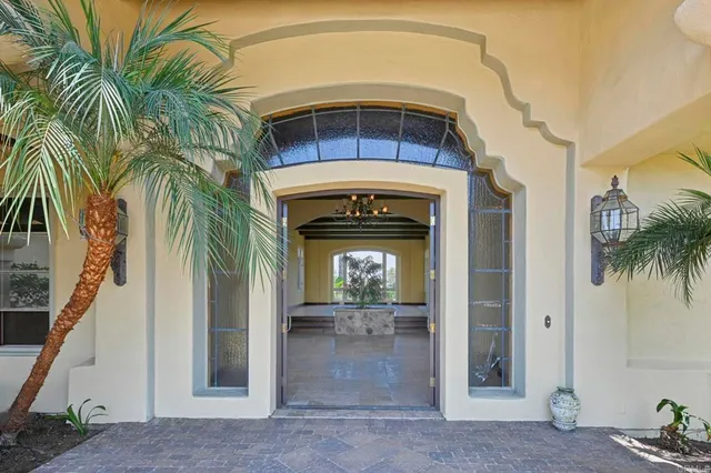 a view of a hallway with a chandelier a flat screen tv and a fireplace