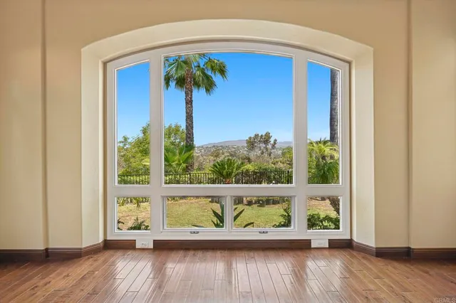 a view of empty room with wooden floor and fireplace