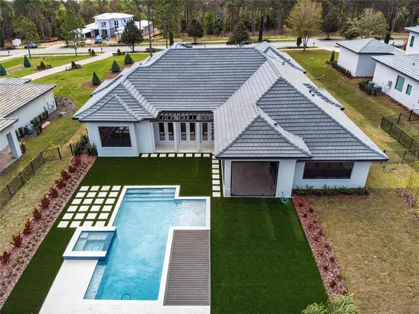 a view of a house with pool and chairs