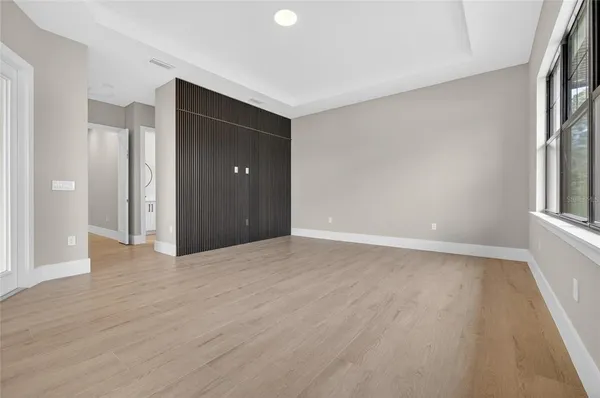 a view of an empty room with closet and a bathroom