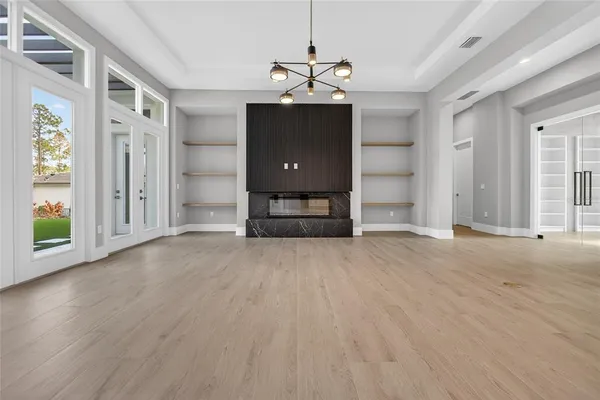 a view of an empty room with window and cabinet