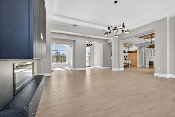 a large kitchen with stainless steel appliances a large counter top a stove and a chandelier
