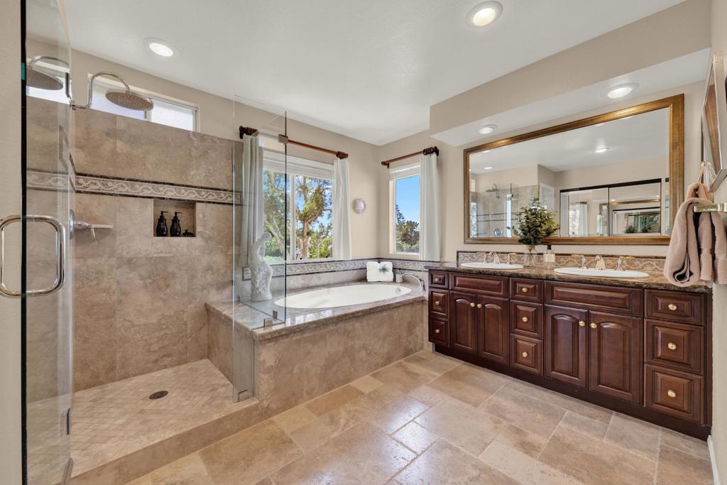 3761 Hillview Way Oceanside, CA 92056 - Photo 57 of 75 a spacious bathroom with a granite countertop tub shower double sink and mirror