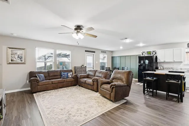 a living room with furniture a dining table and wooden floor