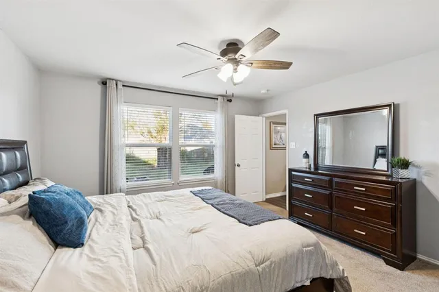 a bedroom with a bed and a mirror on dresser