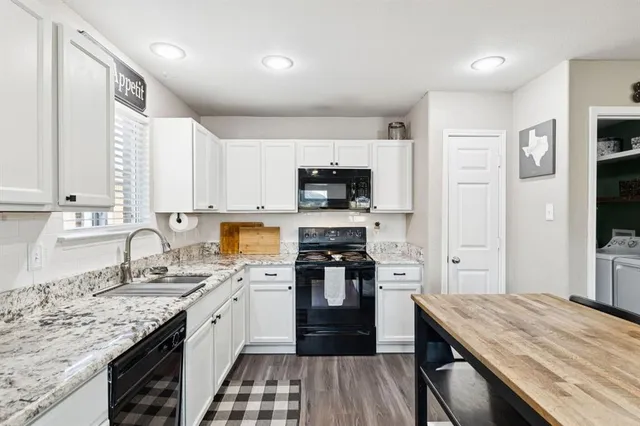 a kitchen with a sink stove top oven and refrigerator