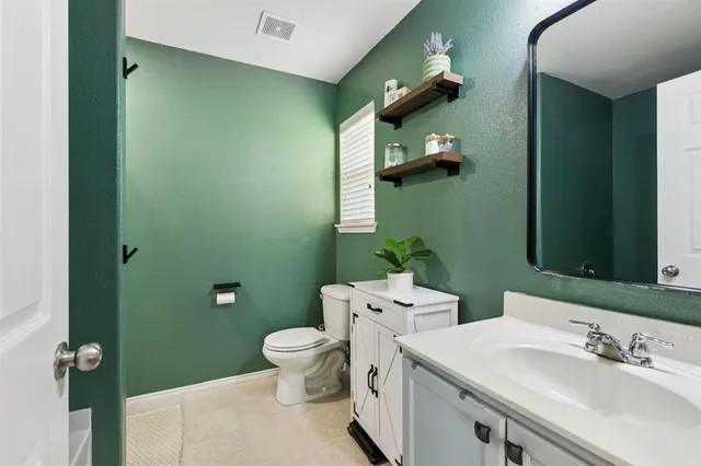 a bathroom with a toilet sink and mirror