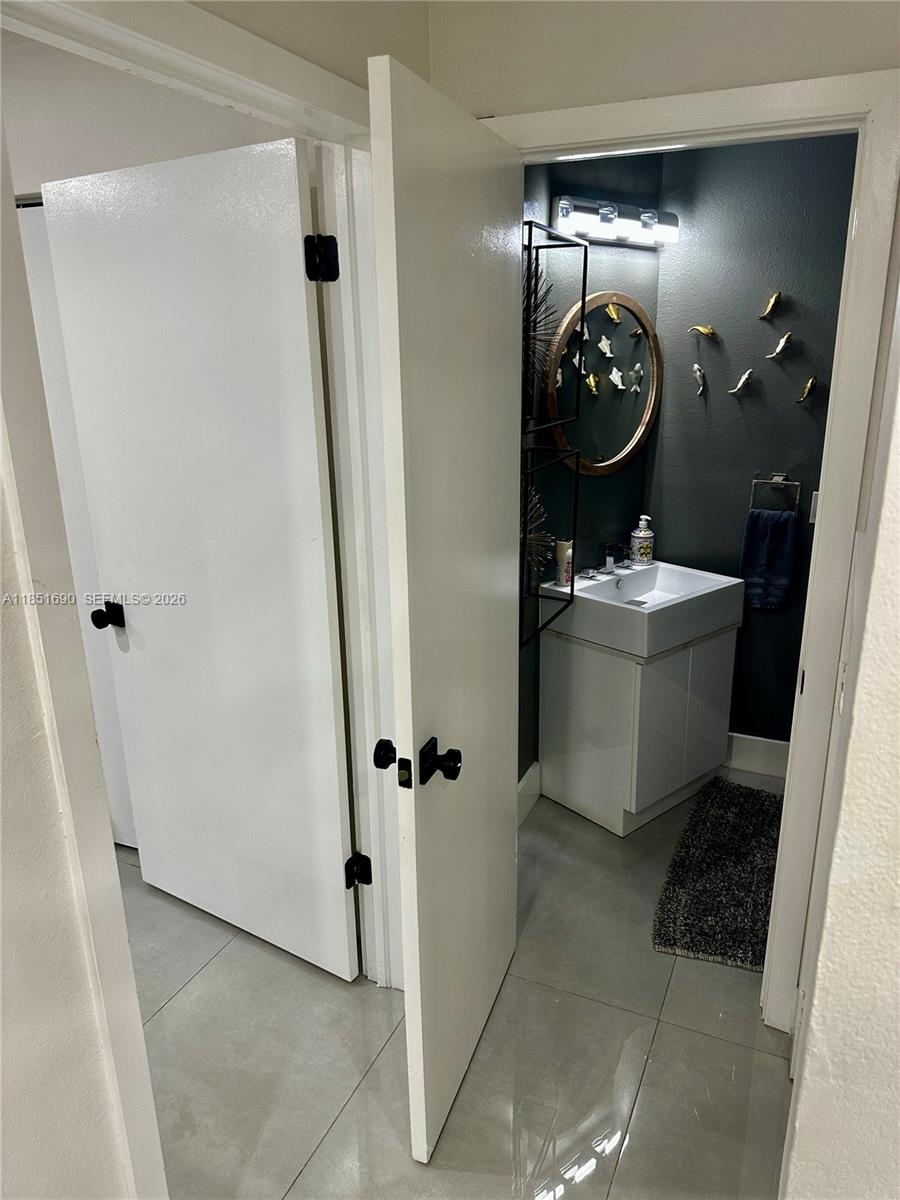 11 Northeast 151st Street Miami, FL 33162 - Photo 22 of 95 a bathroom with a sink and mirror with toilet