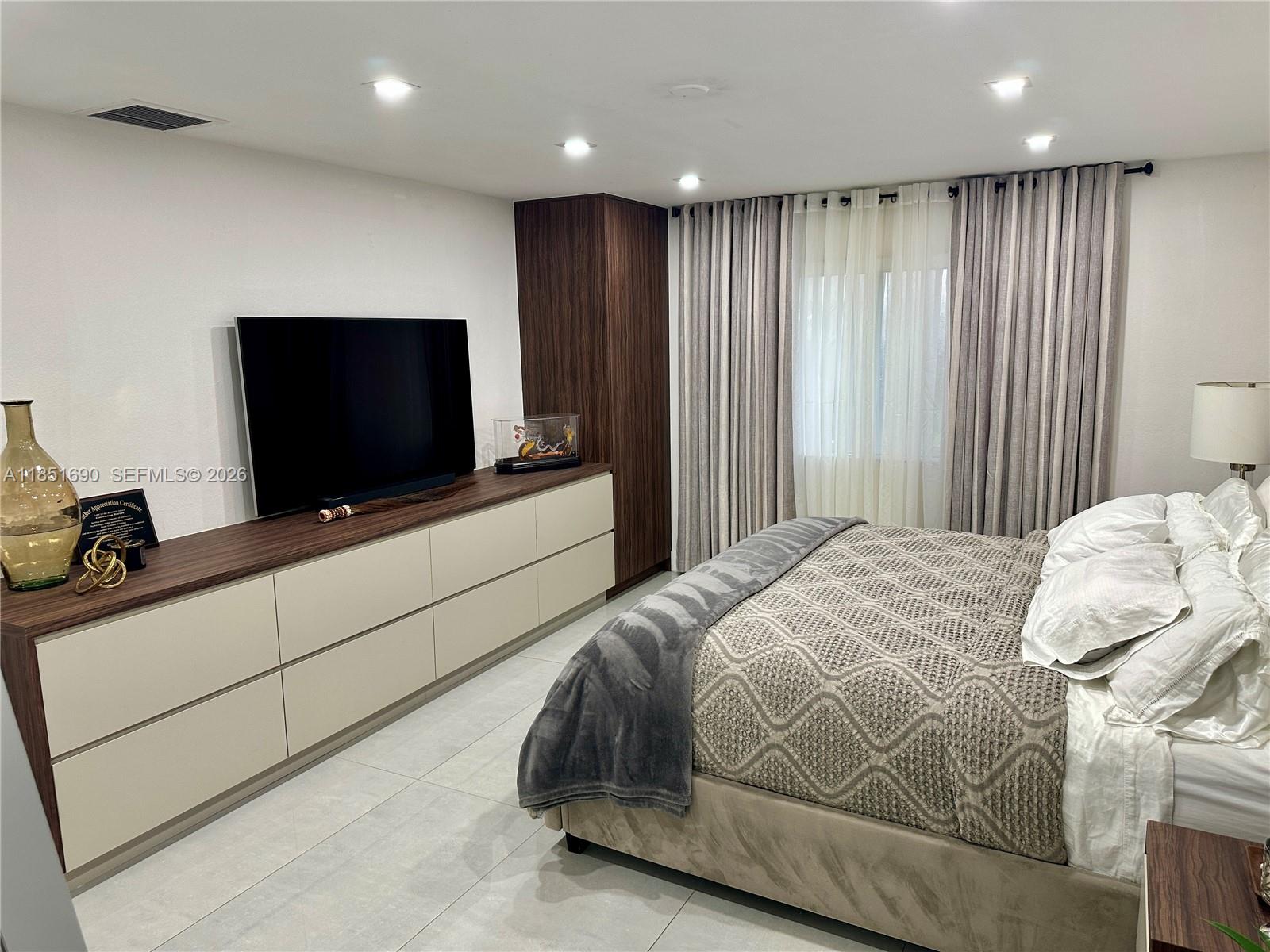 11 Northeast 151st Street Miami, FL 33162 - Photo 27 of 95 a bedroom with a bed and a flat screen tv