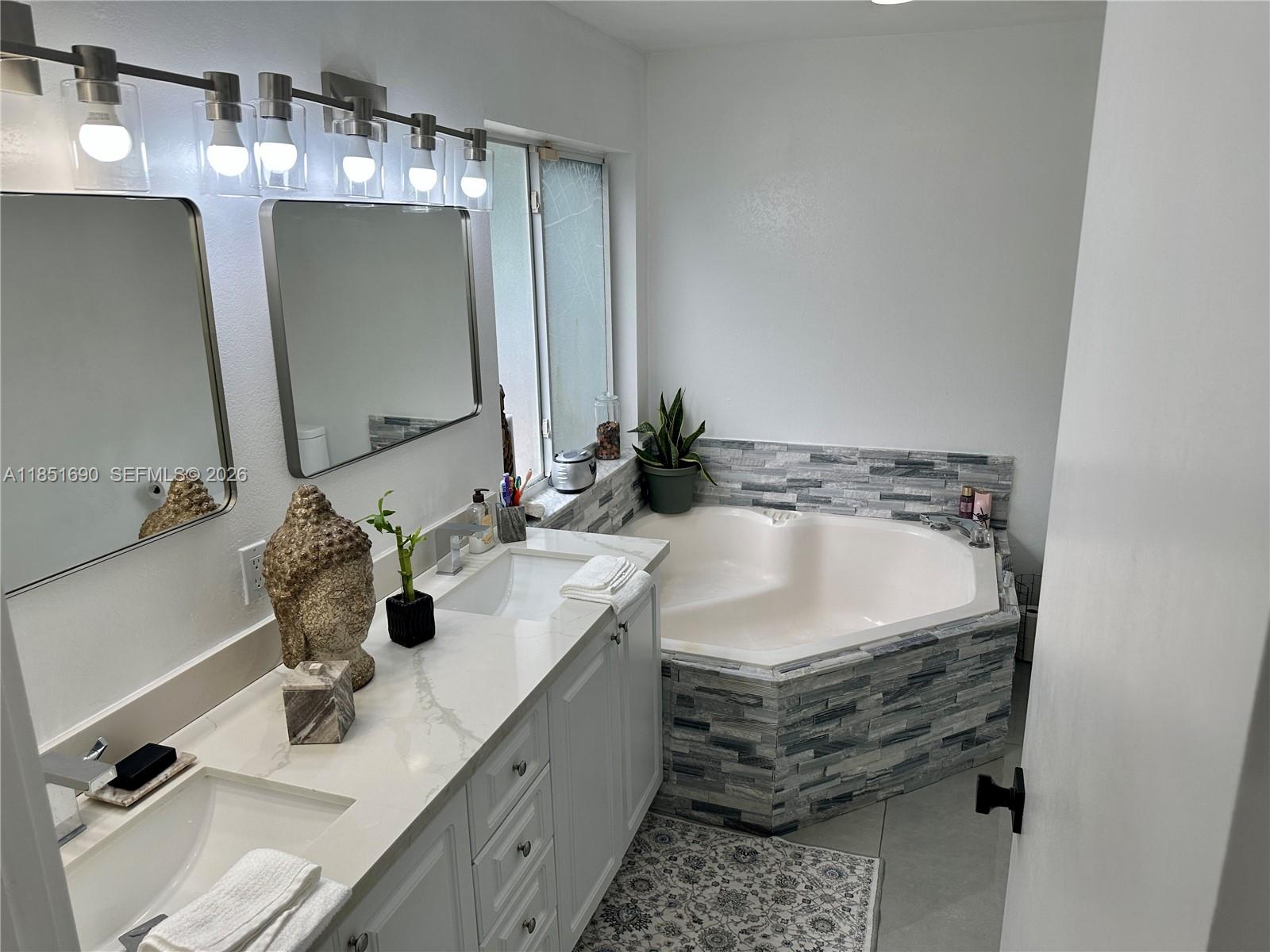 11 Northeast 151st Street Miami, FL 33162 - Photo 30 of 95 a bathroom with a double vanity sink and mirror