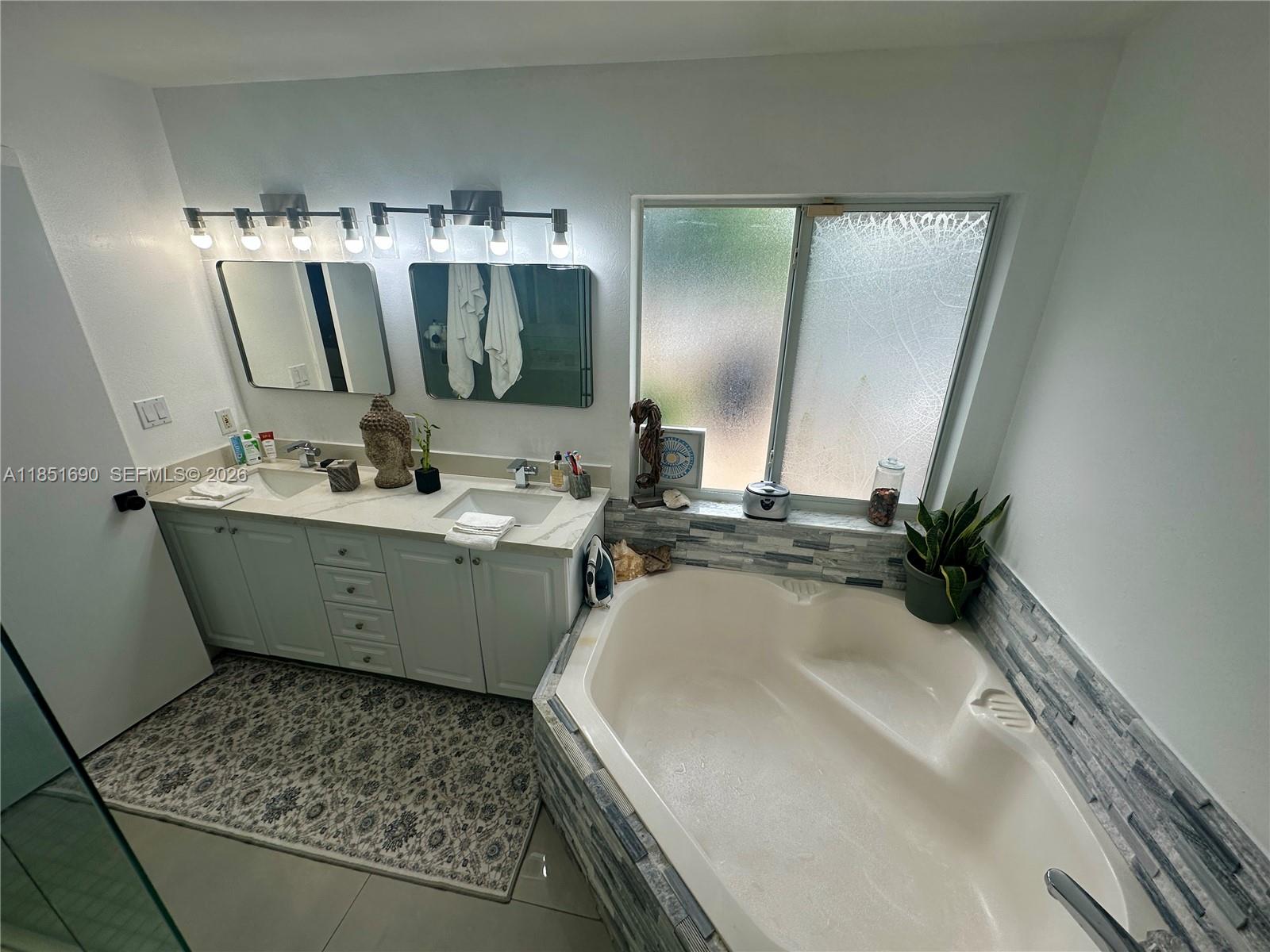11 Northeast 151st Street Miami, FL 33162 - Photo 31 of 95 a bathroom with a double vanity sink and mirror