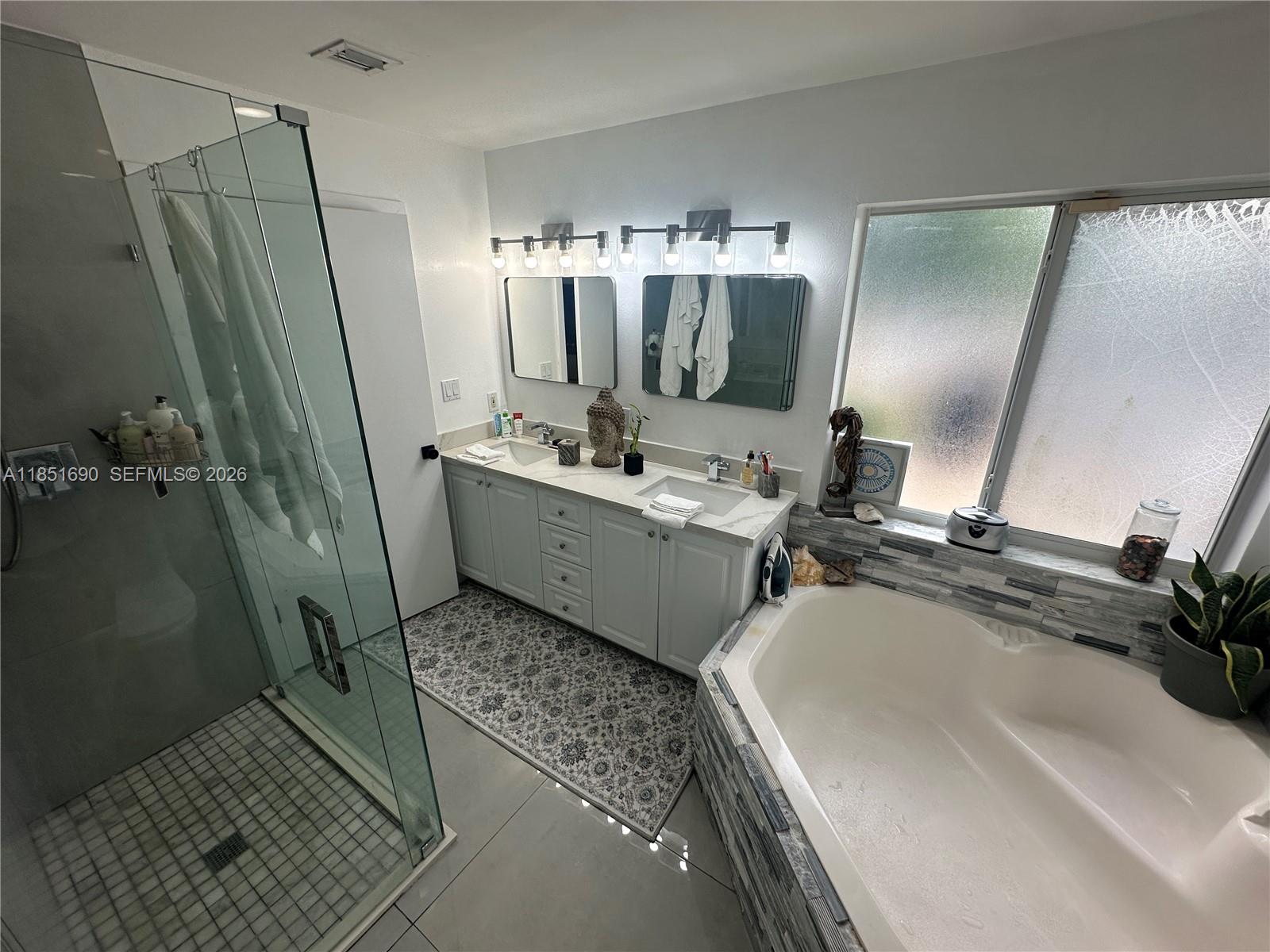 11 Northeast 151st Street Miami, FL 33162 - Photo 33 of 95 a bathroom with double vanity and a bathtub